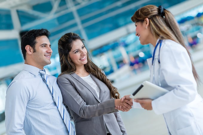 Clientes de Servicios Hospitalarios estrechando la mano de profesional médico